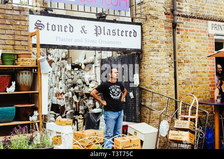 London, Regno Unito - 22 Luglio 2018: venditore in piedi di fronte alla sua bottega, Ezra Street, East London, Regno Unito Foto Stock