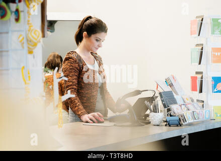 La donna caucasica lavorando in negozio Foto Stock