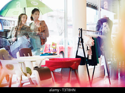 Donne caucasici window shopping al di fuori del negozio Foto Stock