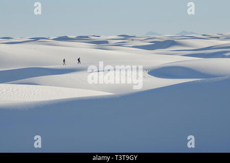 Persone distanti a piedi sul paesaggio innevato Foto Stock
