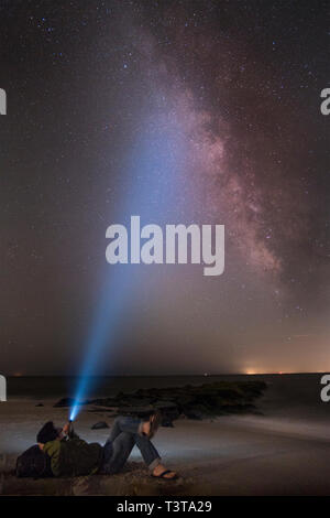 Uomo asiatico shining torcia elettrica sul cielo stellato Foto Stock