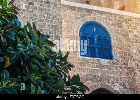 Vecchia casa in Israele con finestre con persiane blu. Edificio storico. Foto Stock