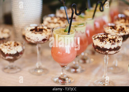 Estate Cocktail a freddo con una vasca. Diversi limonate con cubetti di ghiaccio e le fette di limone a mason jar stare su un tavolo di legno. limonata acqua Foto Stock