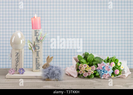 In casa decorazione della tavola per la festa di Pasqua. Blocchi di legno squadrati dipinto di bianco. Testo inglese: felice Pasqua in caratteri di stile. Bunny, farfalle, uovo di pasqua e Foto Stock