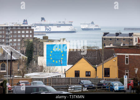 Qual è il prossimo passo per Brexit?? Un traghetto che si avvicina al porto di Dover dove Banksy il famoso murale Brexit gabbie grandi sul lato di un edificio abbandonato. Pict Foto Stock