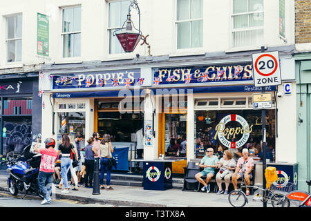 London, Regno Unito - 22 Luglio 2018: la gente seduta su una panchina e camminare vicino a Poppie, famoso fish & chips shop in Spitalfields, Londra Foto Stock