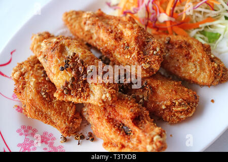 Piastra della Thailandia del Nord profondo fritto di pollo ala con acqua calda e erbe aromatiche Foto Stock