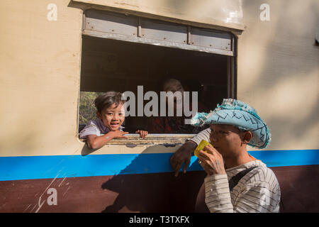 Famiglia birmano rilassante durante una sosta nella stazione ferroviaria di Pyin-U-Lwin, Myanmar. Foto Stock