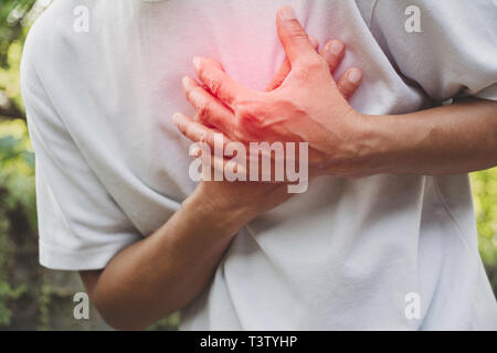 Uomo che soffrono di dolore al petto. Il dolore acuto in un Muscolo uomo concetto con macchia rossa. Foto Stock