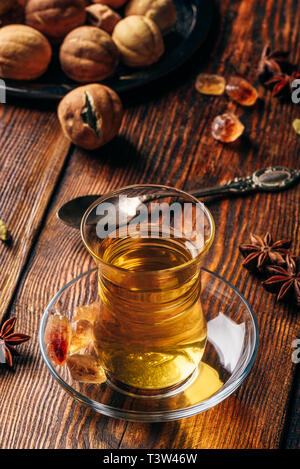 Il tè speziato con anice stellato, cardamomo e essiccato in calce vetro orientali su una superficie di legno Foto Stock