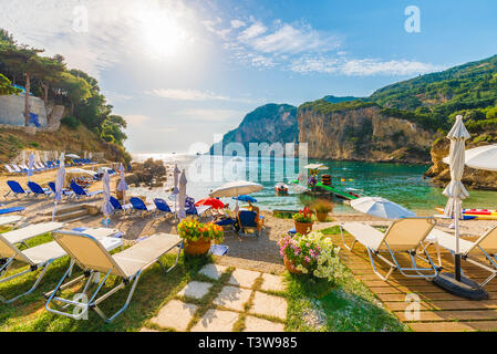 Lettini e ombrelloni sulla spiaggia di Isola di Corfù, Grecia. Foto Stock