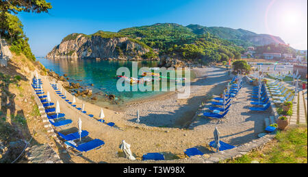 Lettini e ombrelloni sulla spiaggia di Isola di Corfù, Grecia. Foto Stock