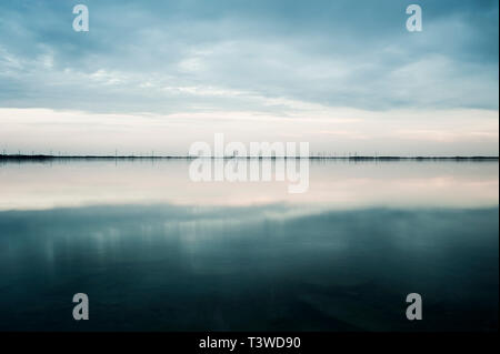 Nuvole riflettono ancora in lago rurale Foto Stock