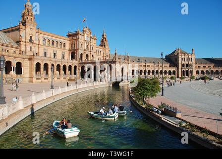 Persone imbarcazioni a remi sul fossato della storica Plaza de Espana in Siviglia, in Spagna il 3 aprile 2019. È stato costruito per il 1929 esposizione Ibero-americana. Foto Stock