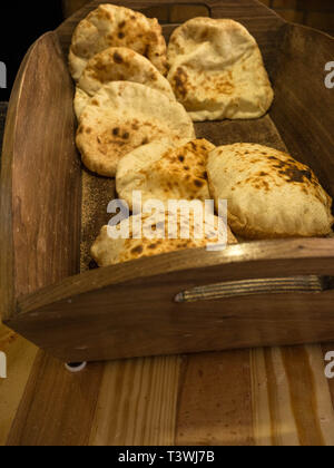 In casa cereali integrali pane pita sul cestello in legno, tradizionale e piatti tipici della cucina araba Foto Stock