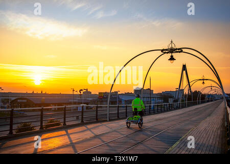 Southport, Merseyside. Il 12 aprile, 2019. Regno Unito Meteo. Freddo, chiaro per iniziare la giornata come pensionati Robert Jones prende come spin sulla batteria Batribike powered trike del resort Pier. Bob può di solito essere visto nel primo mattino godendo il tranquillo paesaggio del nord-ovest della stazione balneare. Credito: MediaWorldImages/Alamy Live News Foto Stock