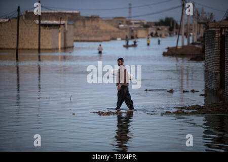 (190412) -- AHVAZ, Aprile 12, 2019 (Xinhua) -- persone wade attraverso le acque di esondazione appena fuori città Ahvaz, capitale della provincia di Khuzestan, Iran, 11 aprile 2019. (Xinhua/Ahmad Halabisaz) Foto Stock