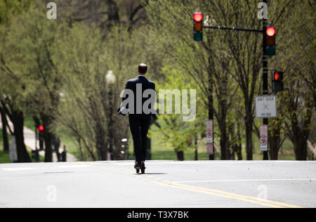 Washington, Germania. 04 apr, 2019. Un uomo in una tuta aziona il suo scooter elettrico attraverso una strada principale a Washington. Credito: Ralf Hirschberger/dpa/Alamy Live News Foto Stock