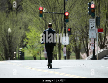 Washington, Germania. 04 apr, 2019. Un uomo in una tuta aziona il suo scooter elettrico attraverso una strada principale a Washington. Credito: Ralf Hirschberger/dpa/Alamy Live News Foto Stock