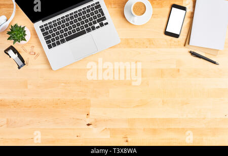 Moderno computer laptop. Vista superiore del legno e di scrivania da ufficio con computer laptop, smartphone, notebook, cuffie, impianti e tazza di caffè. Ufficio moderno. Foto Stock