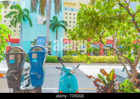 MIAMI USA - giugno 28 2012; colorata scena di strada di art deco colori, architettura e oggetti visti attraverso il framing di alberi verdi Foto Stock