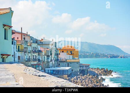 Vecchie case sulla costa rocciosa del mare di Cefalù, Sicilia, Italia Foto Stock