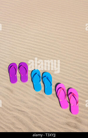 Colorato flip flop sulla sabbia Foto Stock