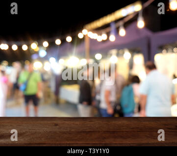 Svuotare tavolo in legno sulla sommità blur abstract notte evento Festival parte dello sfondo. può essere utilizzato per visualizzare o montage i vostri prodotti Foto Stock