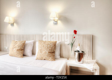 Champagne e bicchieri da letto in camera di albergo Foto Stock
