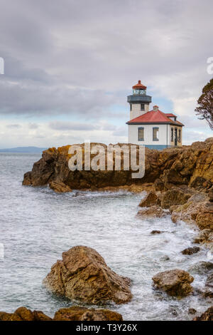 Faro affacciato sulla costa rocciosa Foto Stock