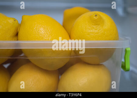 Alimenti biologici sfondo. Cibo sano. Mangiare sano. Dieta. La vitamina C. frutta fresca. Il bar e il concetto reastaurant. Contenitore in plastica con limoni in Foto Stock