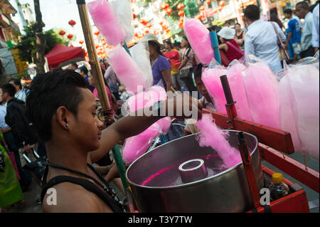 28.01.2017, Yangon, Repubblica dell' Unione di Myanmar, Asia - un giovane uomo è la preparazione di caramella di cotone ad un festival di strada nella ex capitale birmana. Foto Stock