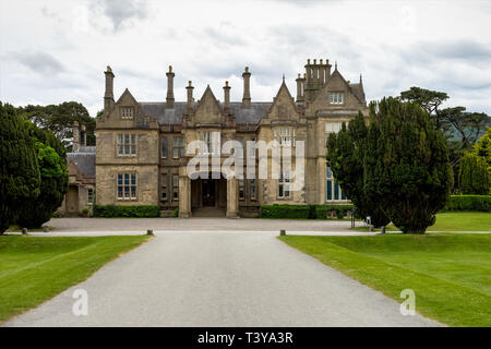 Muckross House e giardini contro il cielo nuvoloso. Si tratta di un palazzo progettato in stile Tudor, situato nel Parco Nazionale di Killarney. Foto Stock