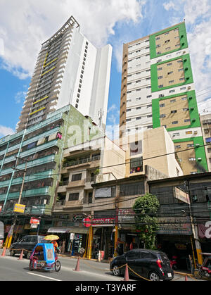 Binondo, Manila, Filippine: a basso angolo di visione di due alto-aumento edifici residenziali e cinese i negozi di proprietà e la strada di fronte Foto Stock