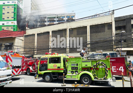 Manila, Filippine: diverse vetture antincendio con i vigili del fuoco al lavoro per cercare di spegnere un incendio in un edificio di appartamenti in Binondo Foto Stock