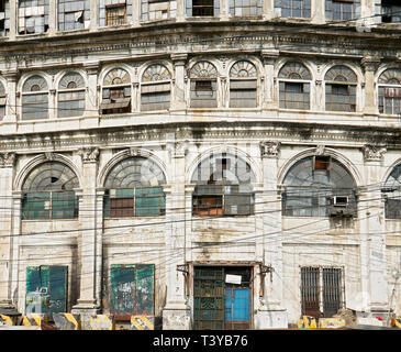 Facciata di un vecchio abbandonato spagnolo edificio commerciale con linee di alimentazione nella parte anteriore, in Escolta, Binondo, vicino al fiume Pasig, Manila, Filippine Foto Stock