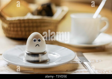 Triste uovo sul tavolo per la colazione Foto Stock