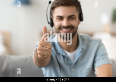 Chiudere su soddisfatto l uomo in cuffia che mostra Thumbs up, approvazione Foto Stock