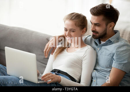 Coppia giovane in amore utilizzando laptop insieme, la visione di film o video Foto Stock