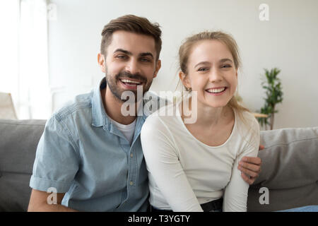 Colpo alla testa ritratto della coppia sorridente, guardare fotocamera, rendendo la chiamata video Foto Stock