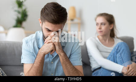 Sconvolto frustrato uomo ignorando donna seduta dietro, pensando Foto Stock