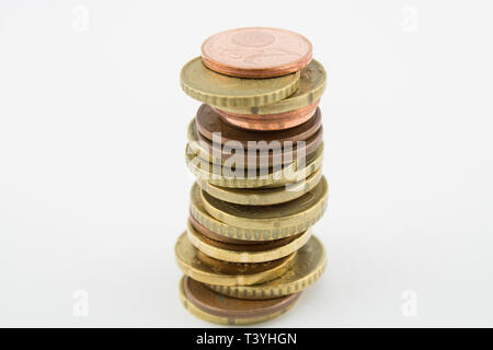 Pila di centesimi di euro monete su sfondo bianco. Monete di diversi valori, cinque, dieci e venti centesimi di euro. Foto Stock