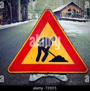 Triangolo di lavori in corso in strada in inverno con il vecchio effetto tonico Foto Stock