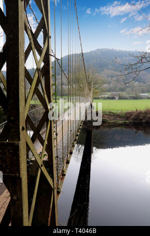 Sospensione piccolo ponte sul fiume con le colline in background Foto Stock