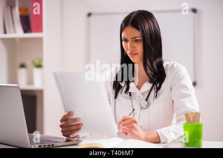 Ritratto di angry medico nel suo ufficio. Foto Stock