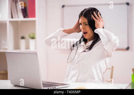 Ritratto di angry medico nel suo ufficio. Foto Stock