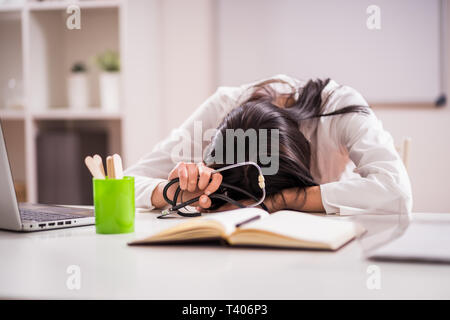 Giovane medico è stanco dal lavoro straordinario. Foto Stock