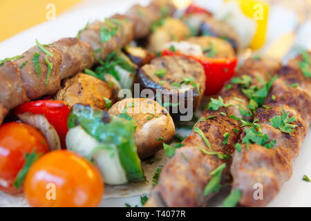 Grigliata di cuori di pollo e verdure su spiedini di metallo Foto Stock