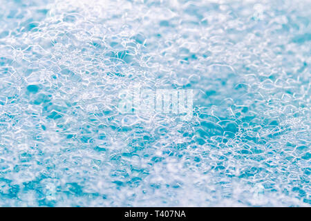 La struttura delle bolle di schiuma di shampoo o agente di pulizia in forma di uno sfondo. Brillanti tonalità blu Foto Stock