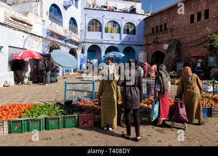 Le donne acquistare frutta e verdura sulla strada del mercato di Chefchaouen, Marocco Foto Stock